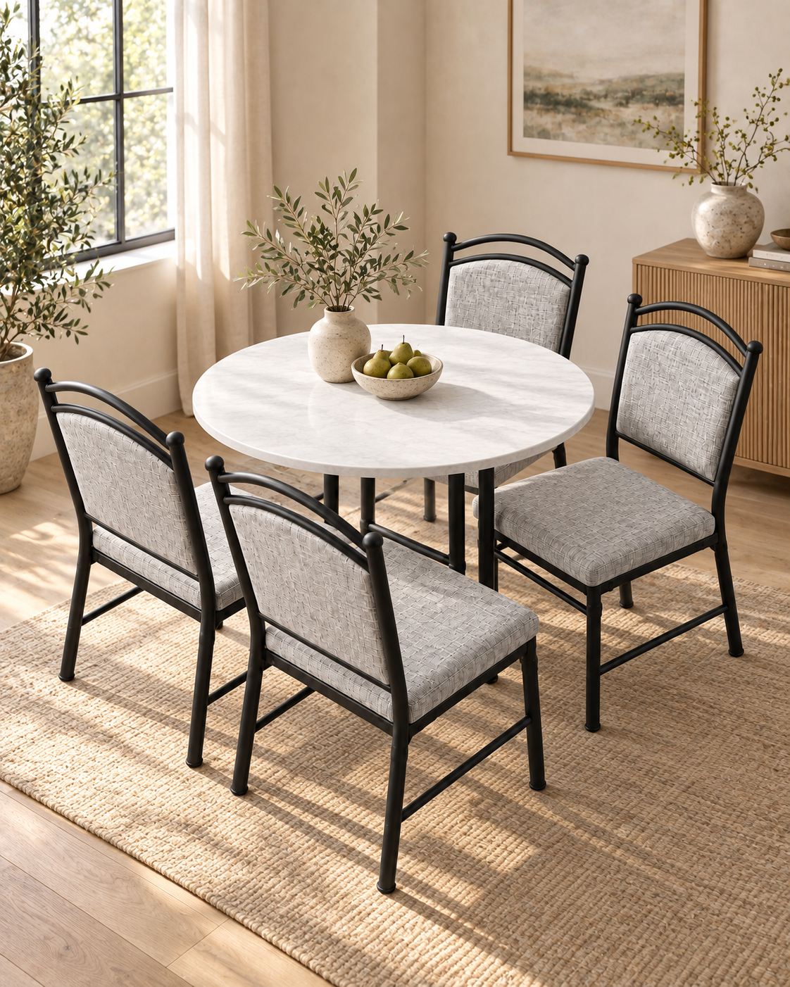 Round dining table handcrafted in Kenya with a pale veined top and slim black legs, set with four grey upholstered chairs on a jute rug