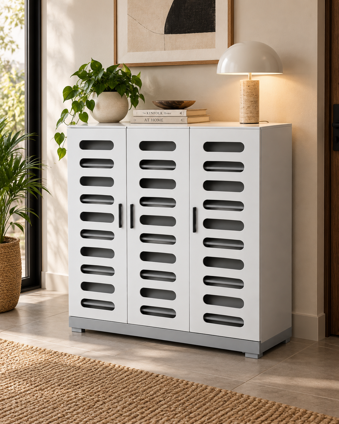White three-door shoe cabinet with rounded ventilation slots and grey plinth, handmade in Kenya, in a sunlit hallway
