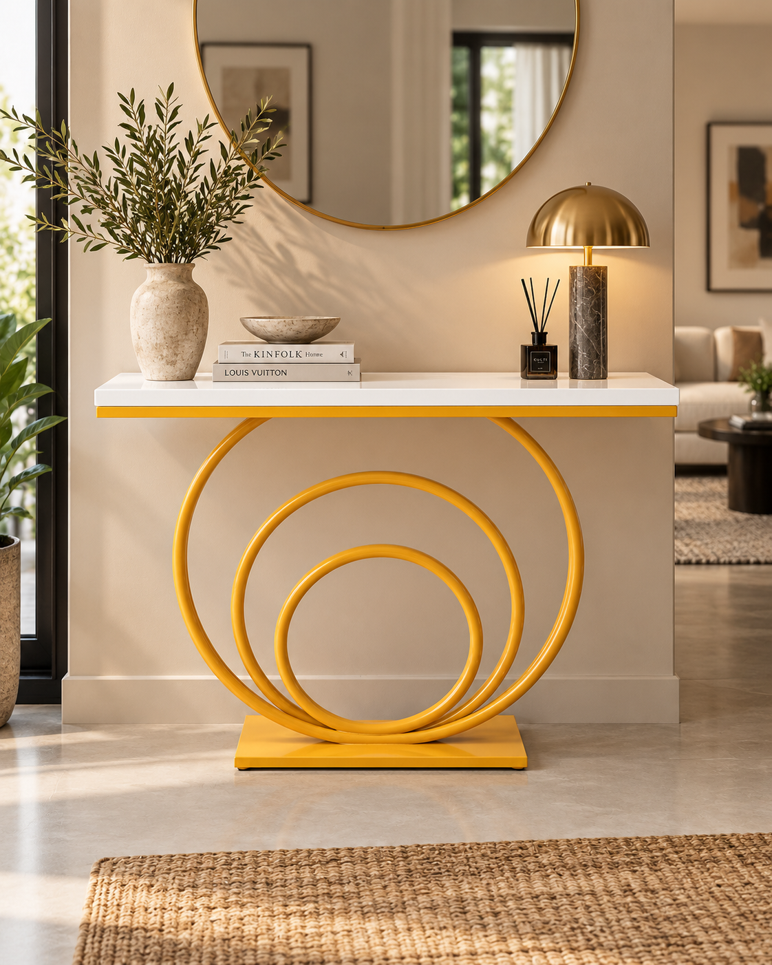 Console table handcrafted in Kenya with three nested glossy yellow metal rings under a white top, styled in a sunlit hallway