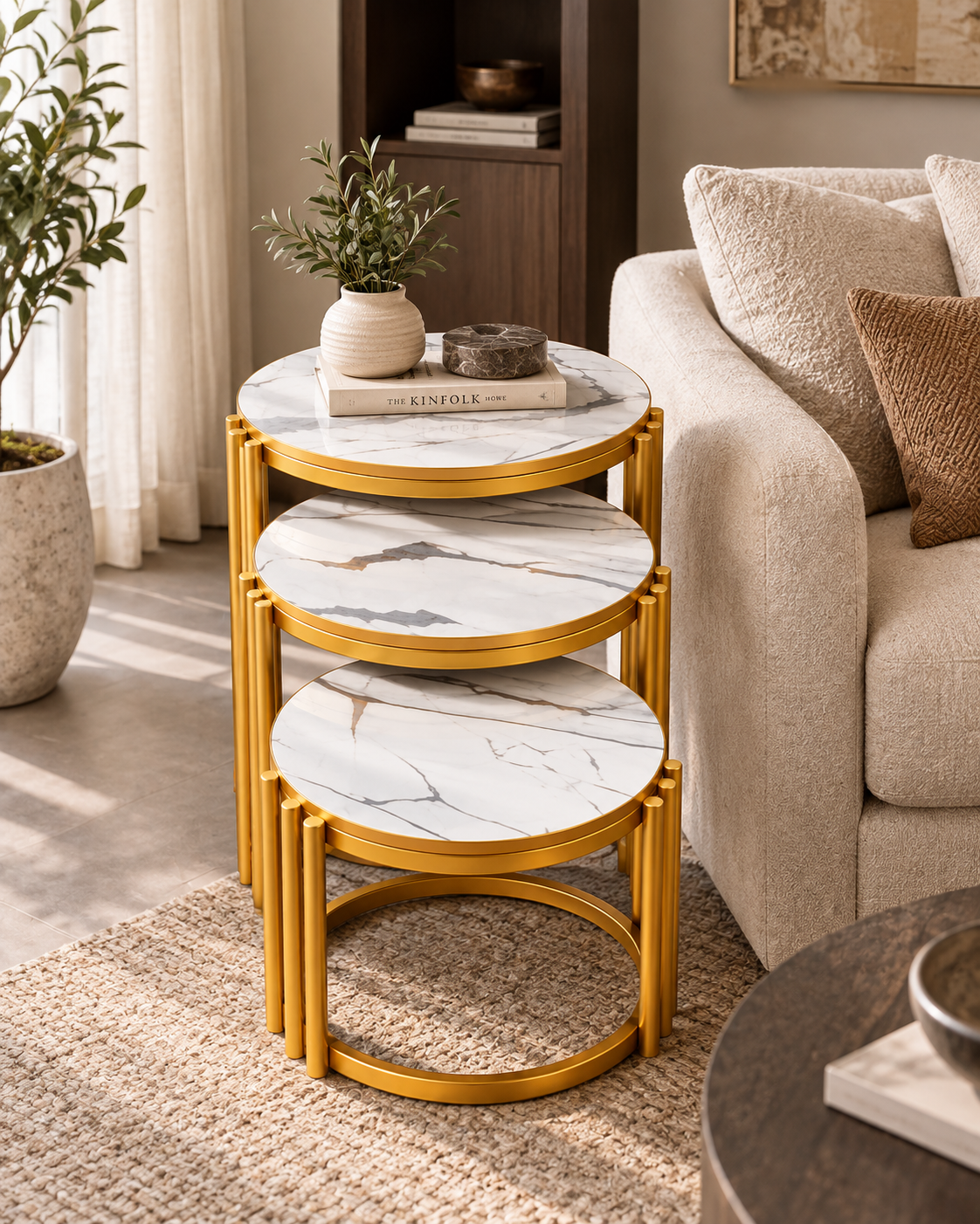 Set of three round nesting side tables from Kenya with white veined marble tops on gold-toned metal rod frames, beside a cream sofa